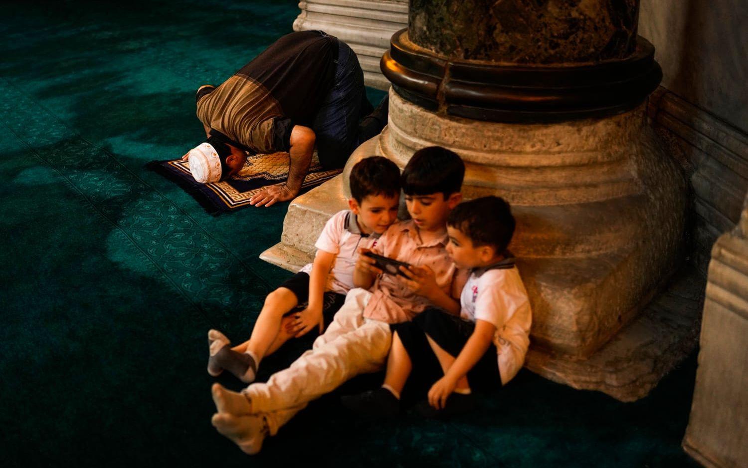 Barn tittar på en telefon i Istanbulmoskén Hagia Sofia. Bild från 2022.