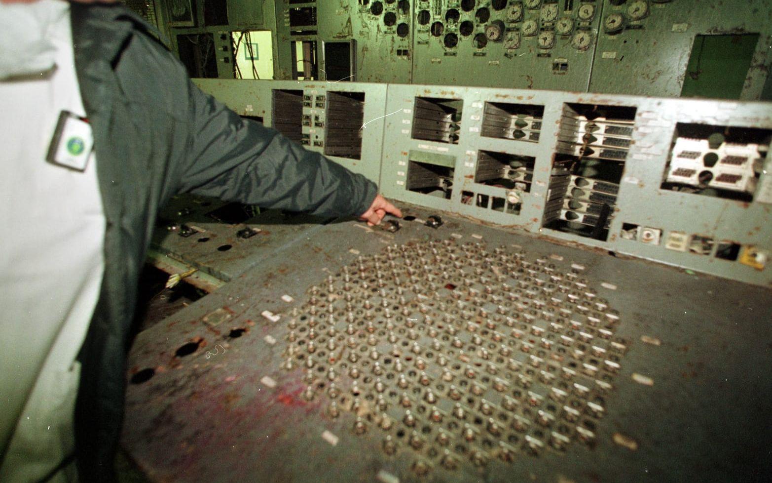 En man pekar på den plats där säkerhetsbrytaren till reaktor 4 en gång satt och som vreds om natten till den 26 april 1986.  Sedan dess har den blivit stulen av souvernirjägare.