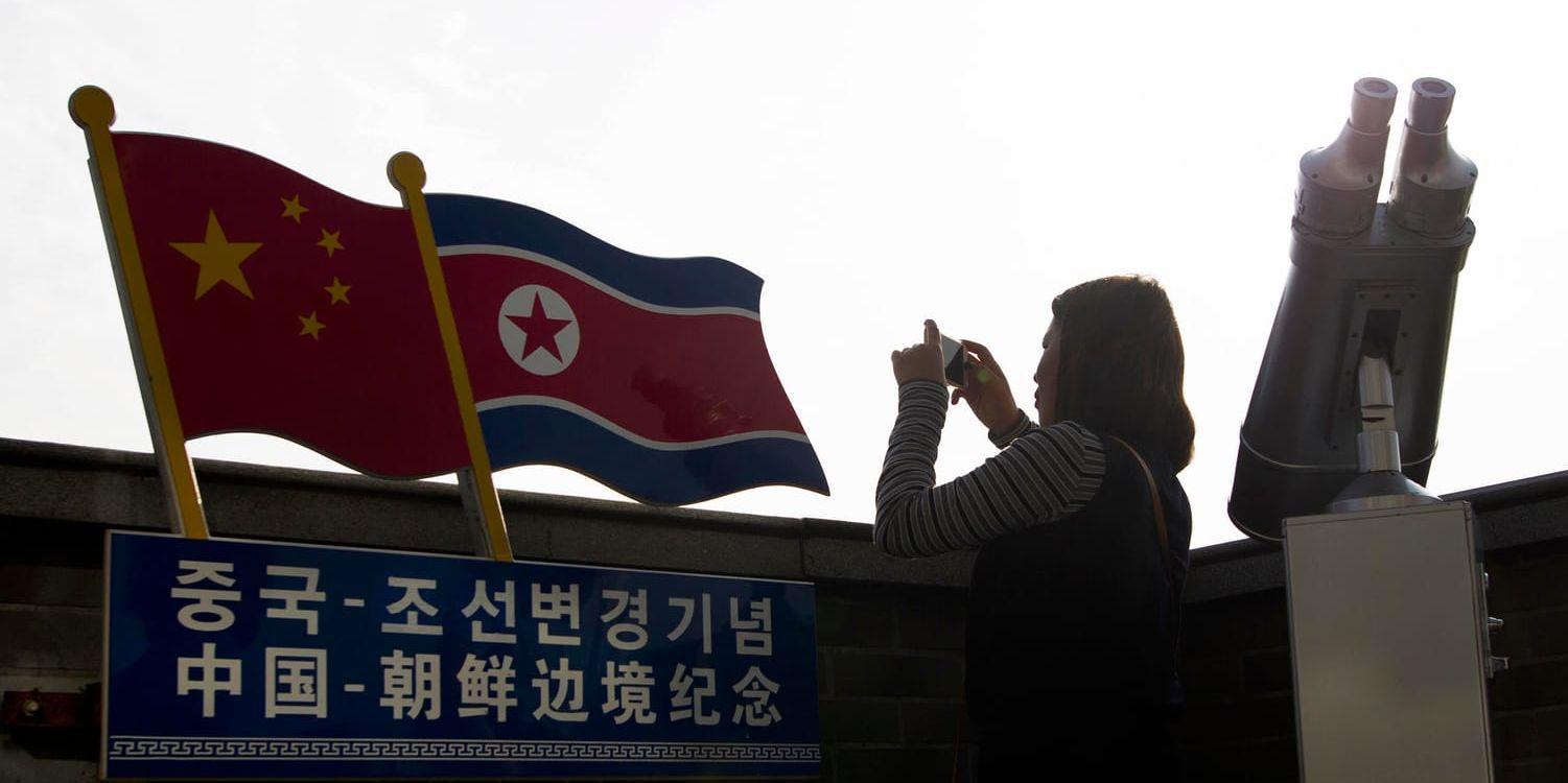 En kinesiska fotograferar vid gränsen mot Nordkorea i Jilin. Arkivbild.