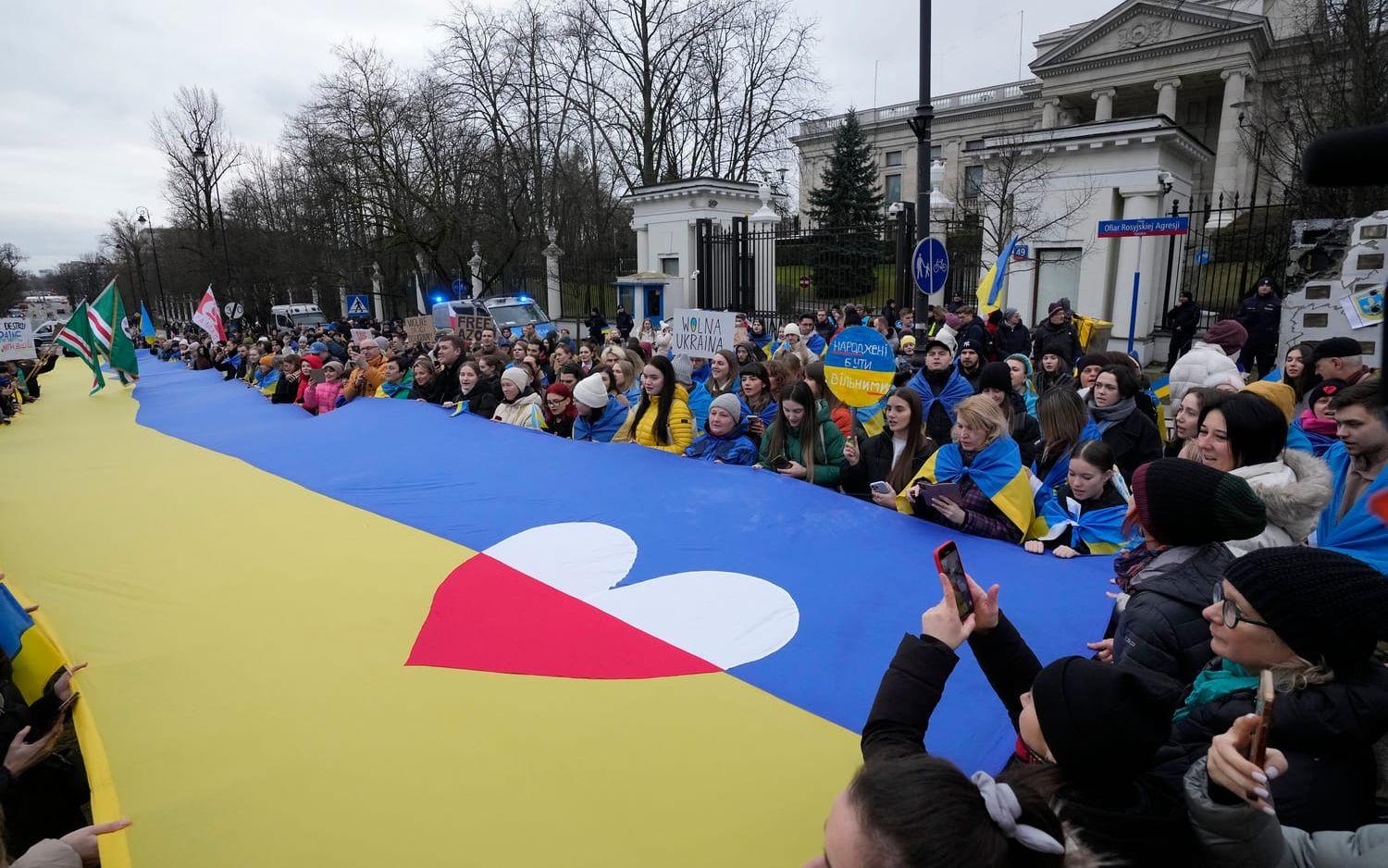 Ukrainare och polacker protesterar mot Rysslands krig i Ukraina framför den ryska ambassaden i Warszawa i februari.