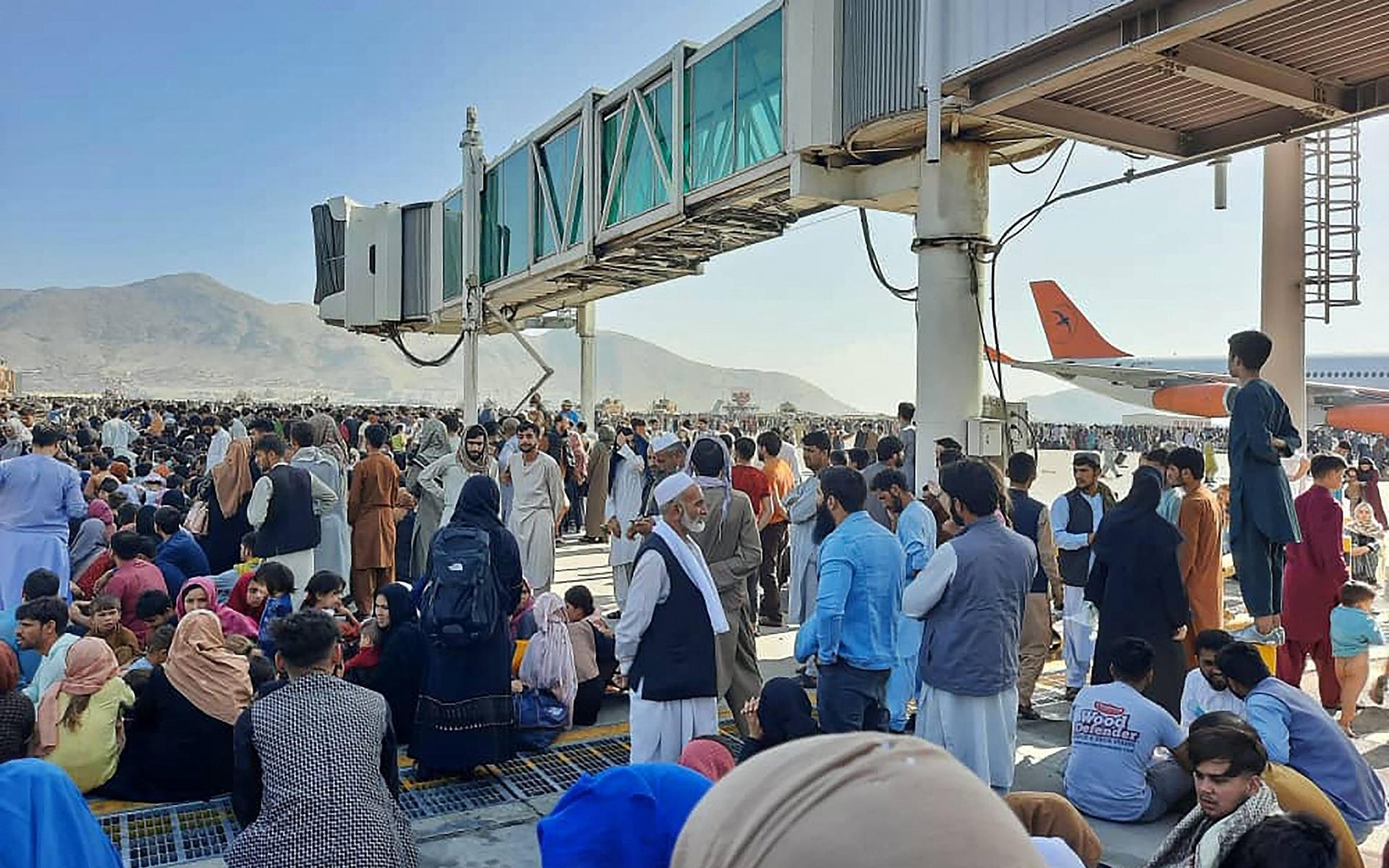 Civila har samlats i massor på landningsbanorna på Kabuls flygplats i hopp om att kunna fly landet.