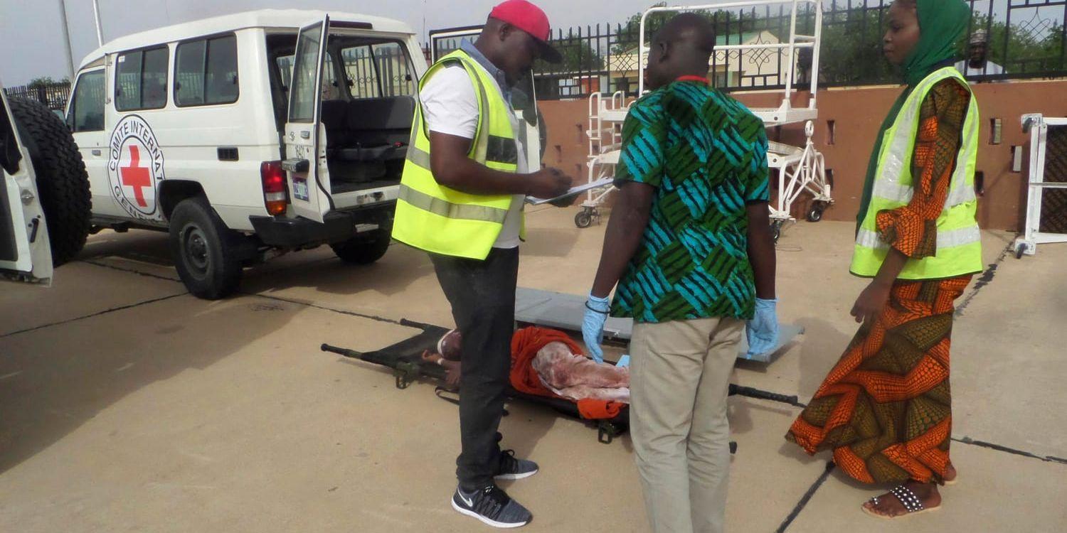 Hjälparbetare från Röda Korset tar emot en av de skadade efter helgens självmordsdåd i Borno i Nigeria. Minst 43 människor dödades i attacken.