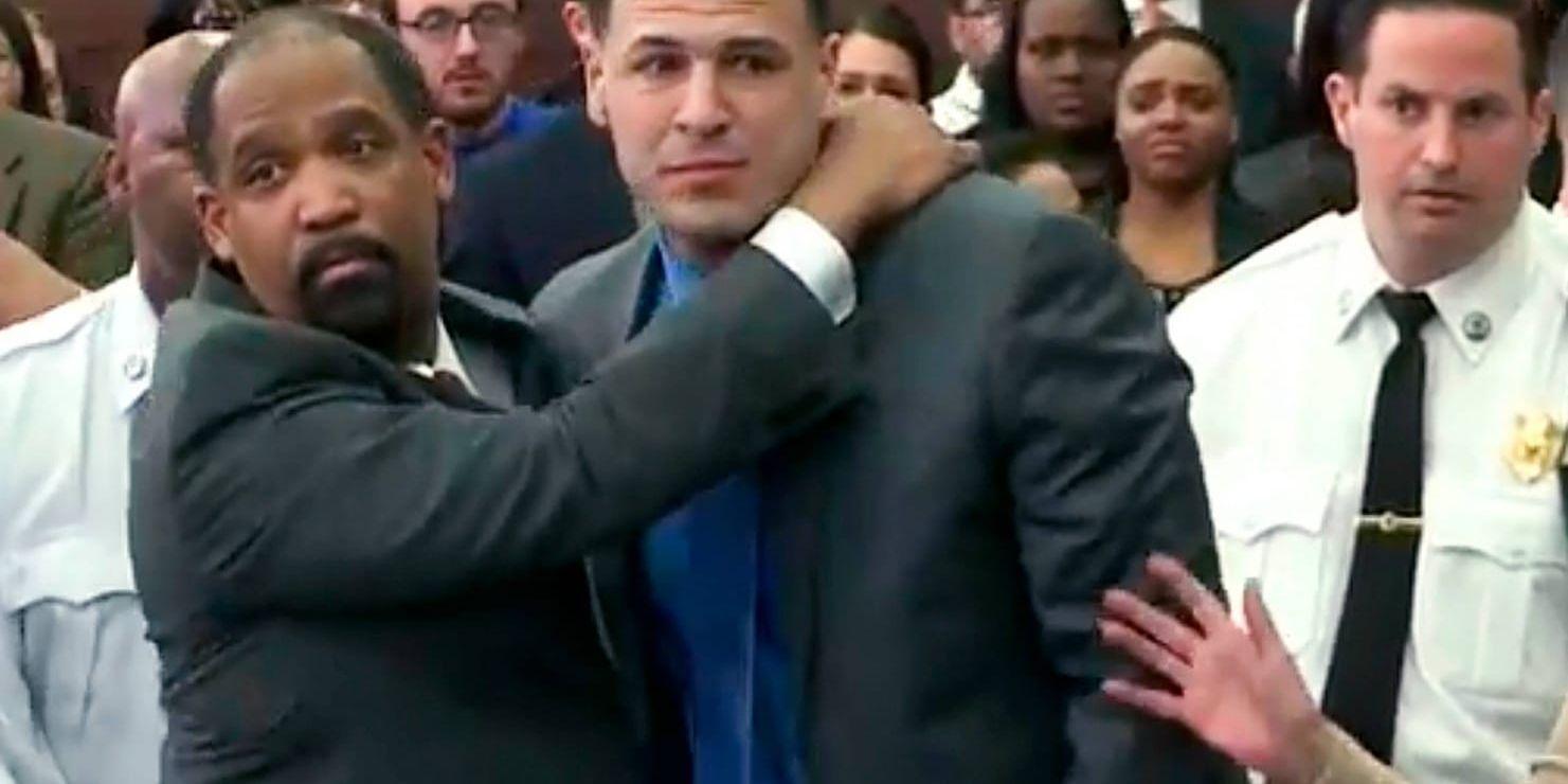 Aaron Hernandez, mitten, kramas om av sin försvarsadvokat efter att ha frias från misstanke om ett dubbelmord.