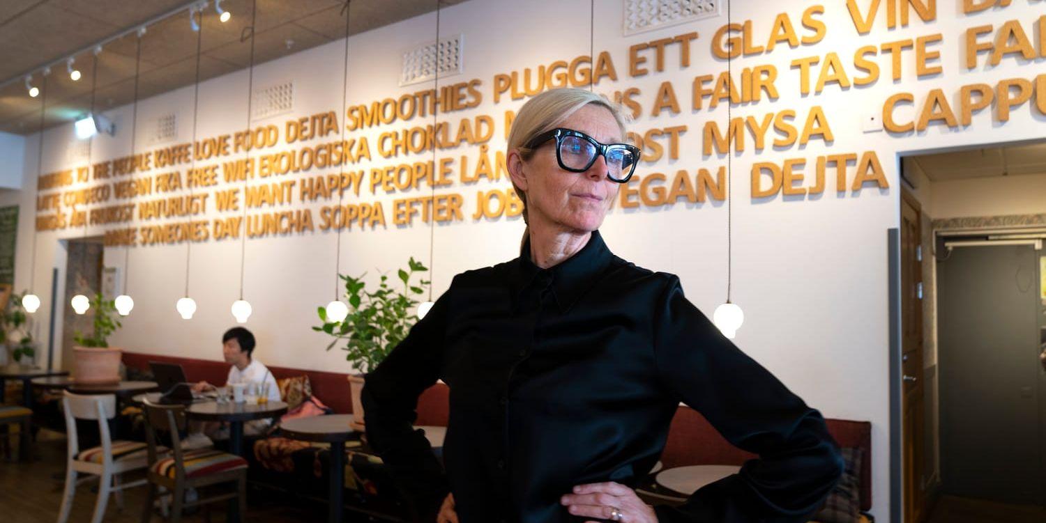 Eva Olsson i ljust hår, svart skjorta och svarta glasögonbågar