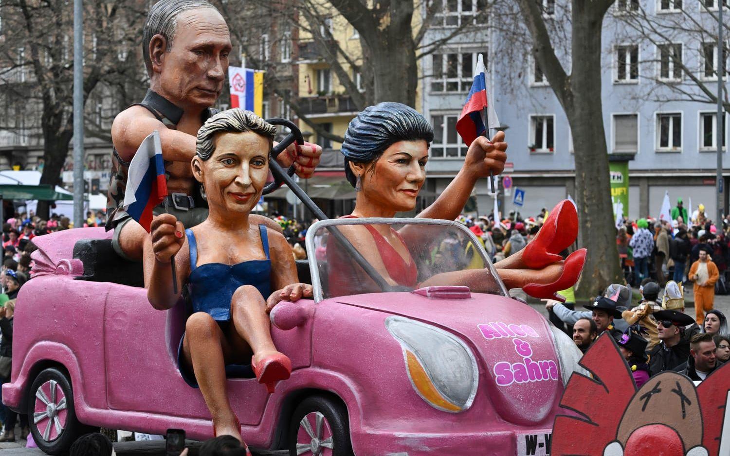Sahra Wagenknecht i vänstersätet, AFD-ledaren Alice Weidel i högersätet och Rysslands president Vladimir Putin som kör från baksätet. Denna satiriska paradvagn rullade fram vid en gatufest i Mainz i februari. Arkivbild.