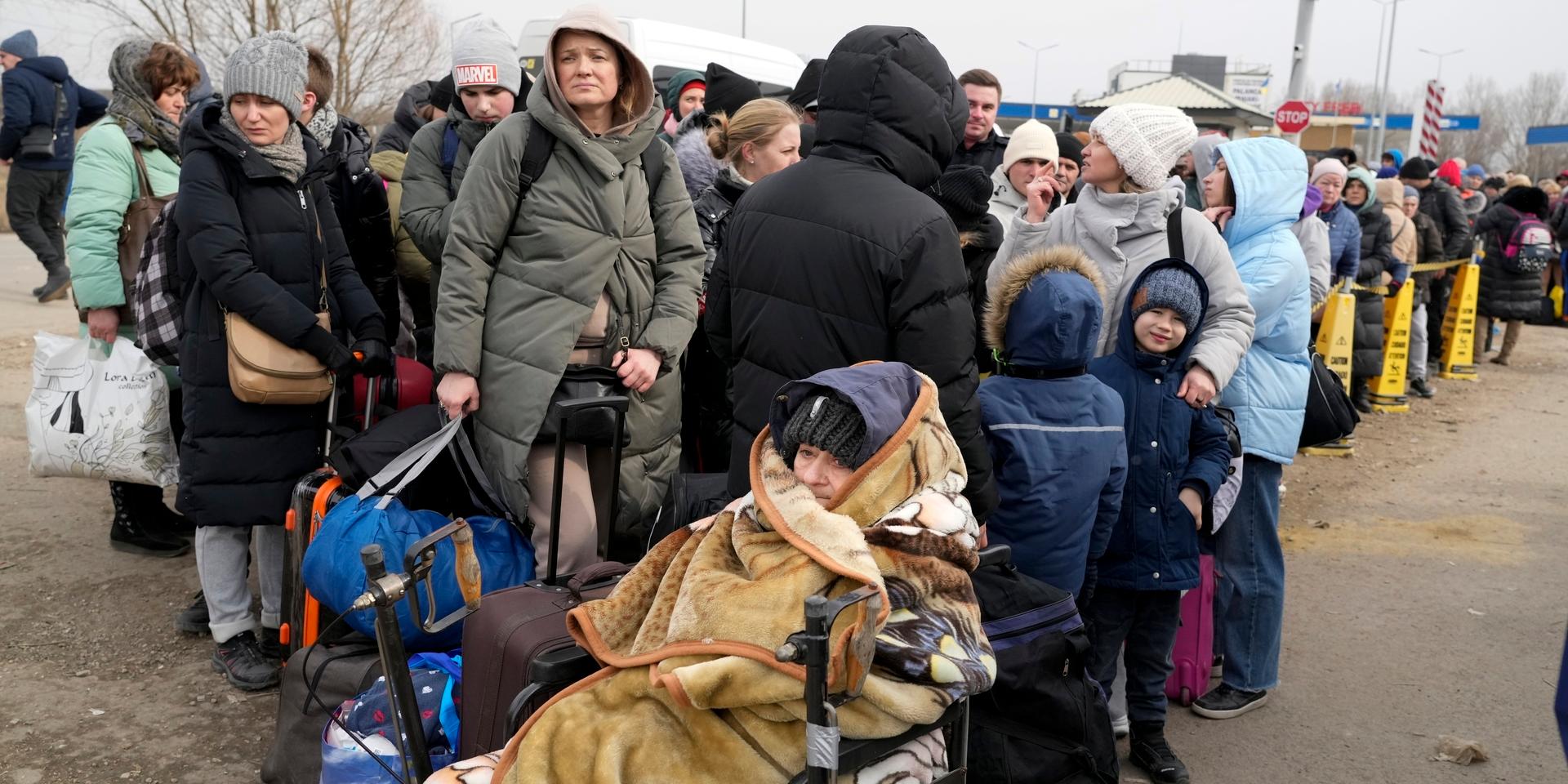 Ukrainska flyktingar köar vid gränsen för att ta sig ut ur det krigshärjade landet. 