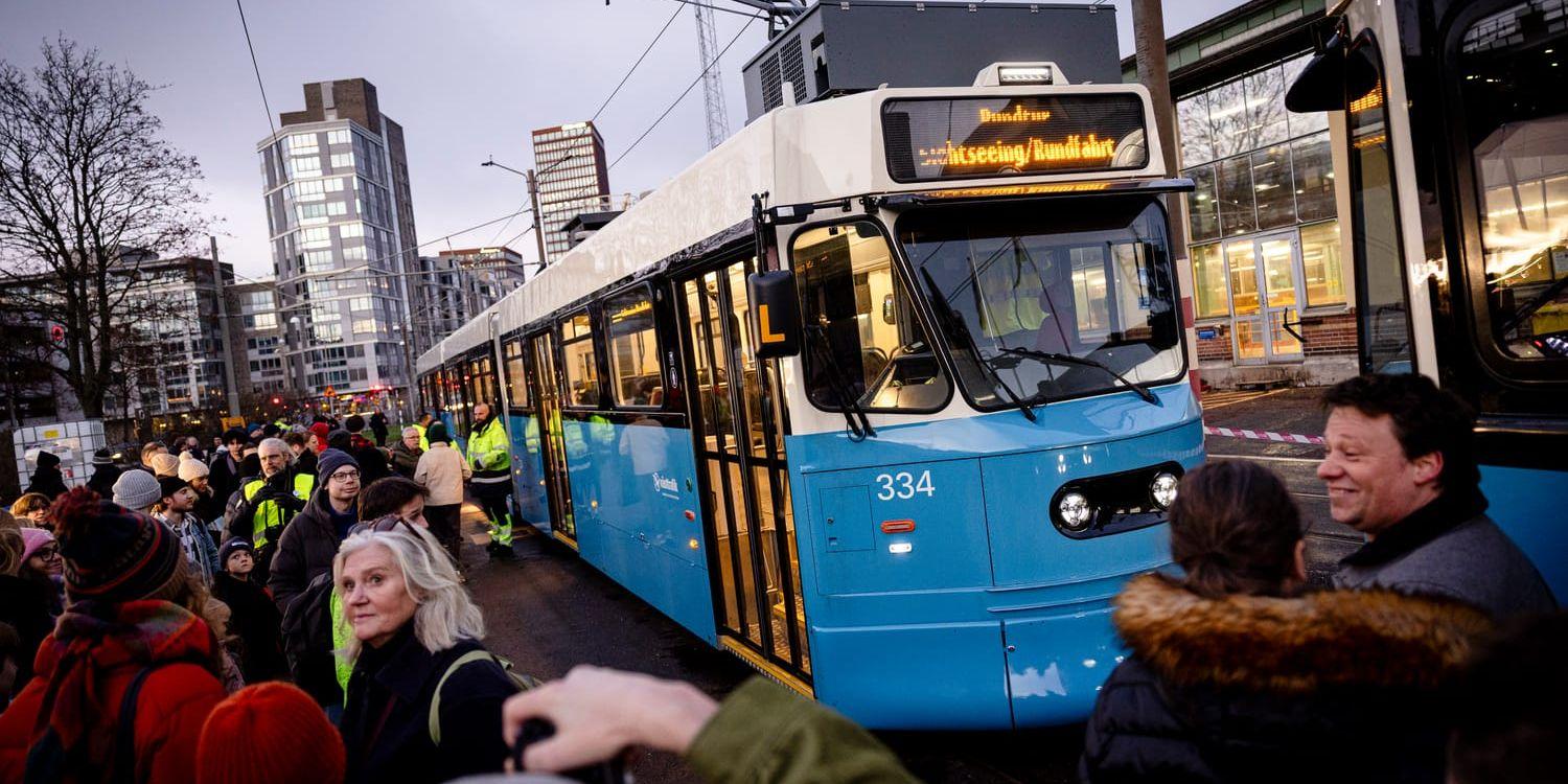 En bild från premiärturen med den nyrenoverade spårvagnsmodellen M31B, där vagnen står parkerad med massa resenärer intill den.