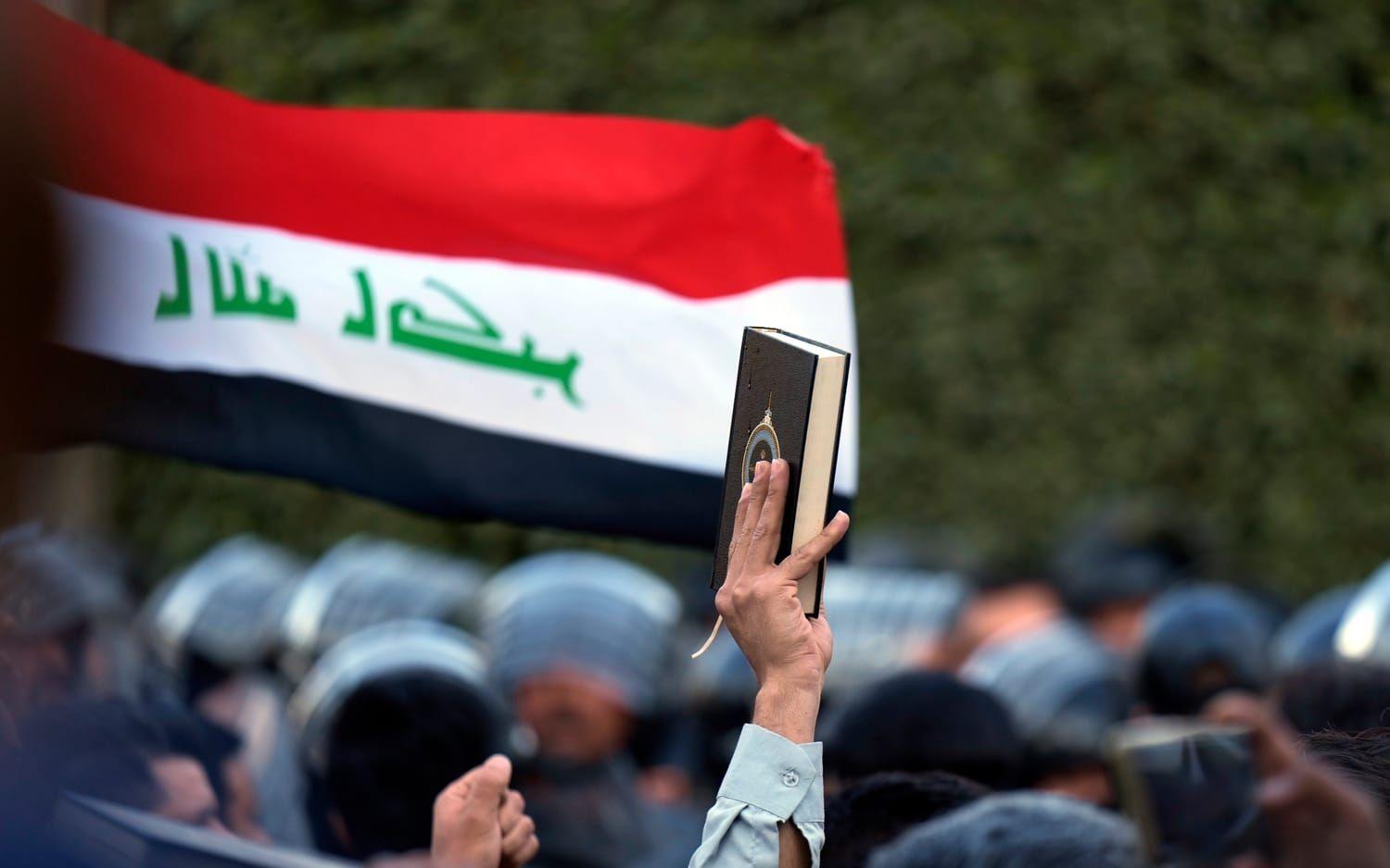 En demonstrant håller uppe en koran under en demonstration mot Sverige i Iraks huvudstad Baghdad. 