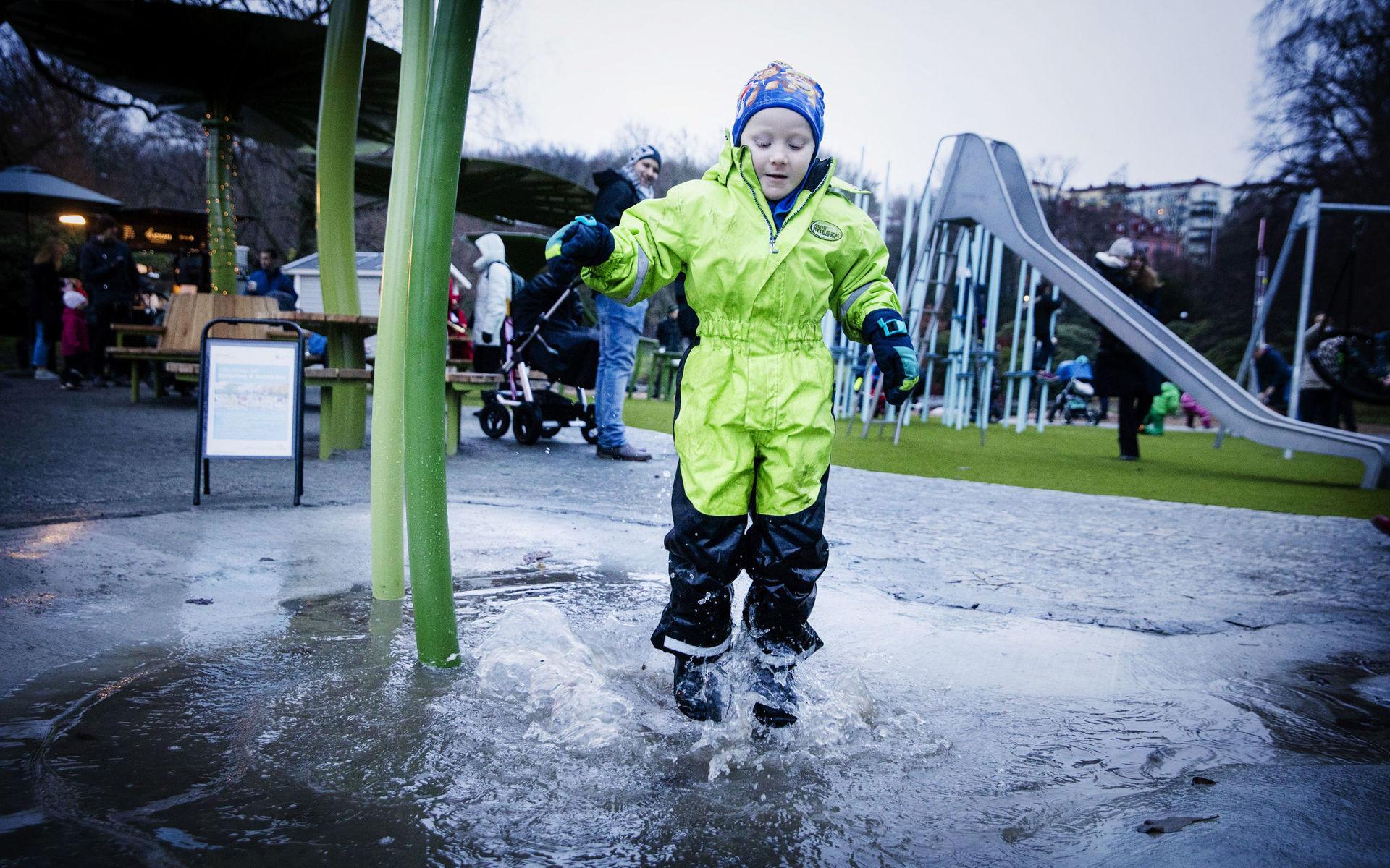 Hej hopp. Måns Ottosson, 5 år, Inviger regnlekplatsen vid Näckrosdammen med jämfotahopp i vattenpölarna.