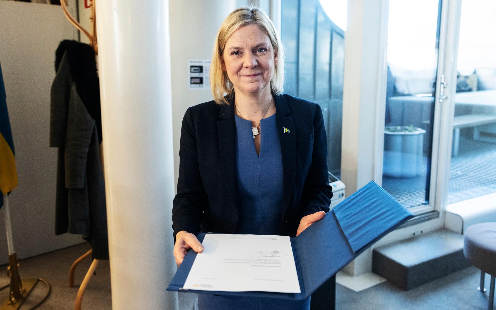 Magdalena Andersson visar upp brevet från talmannen. 