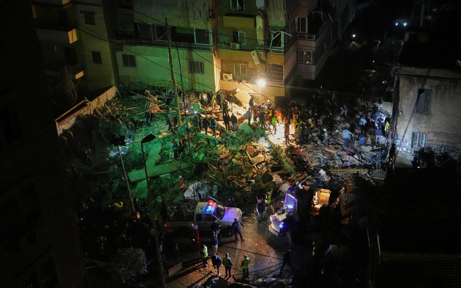 Räddningspersonal söker i rasmassorna efter den israeliska attacken i en förort i södra Beirut.