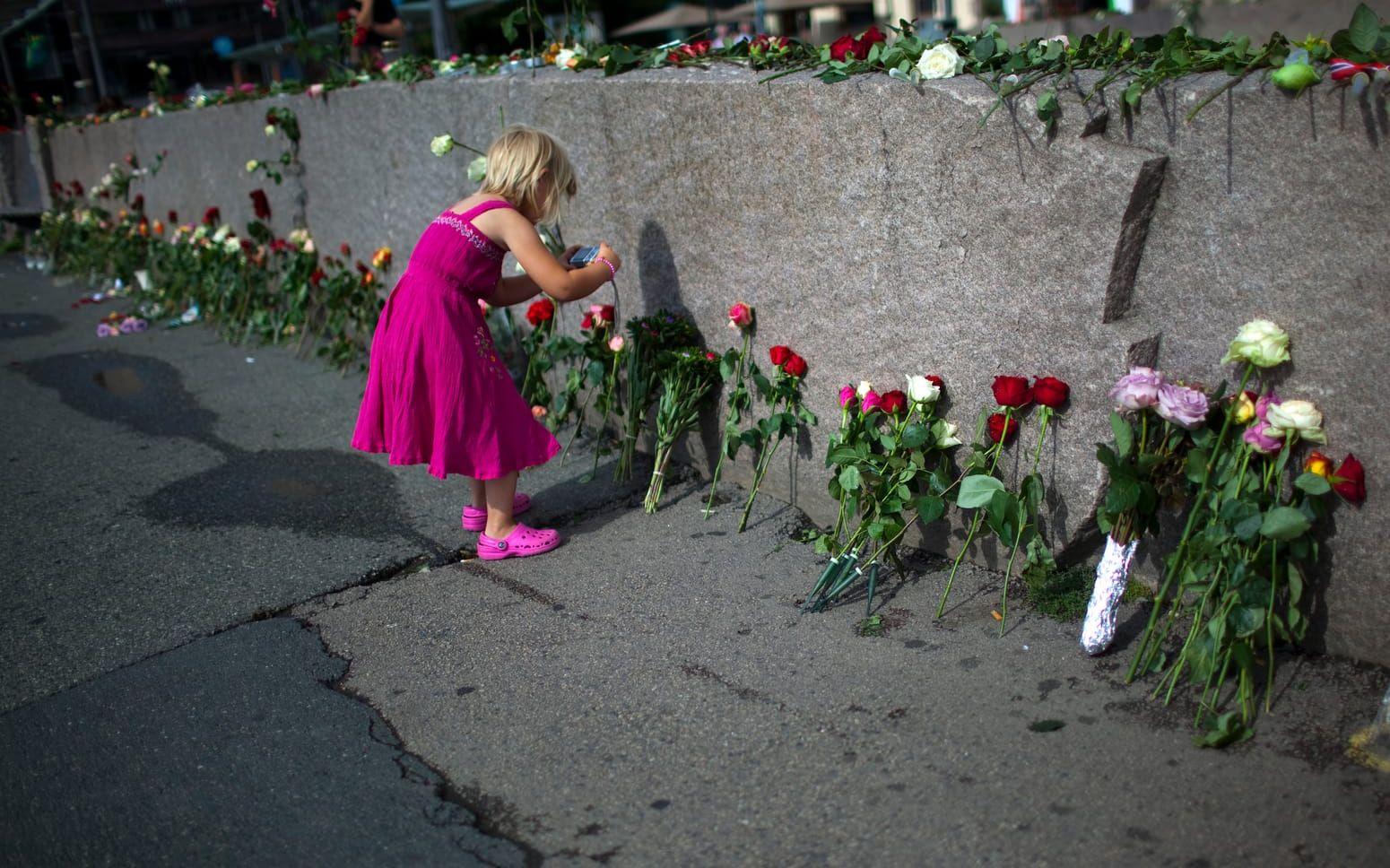 Bild: Emilio Morenatti Flicka tar bilder vid en minnesplats för Breiviks offer. 