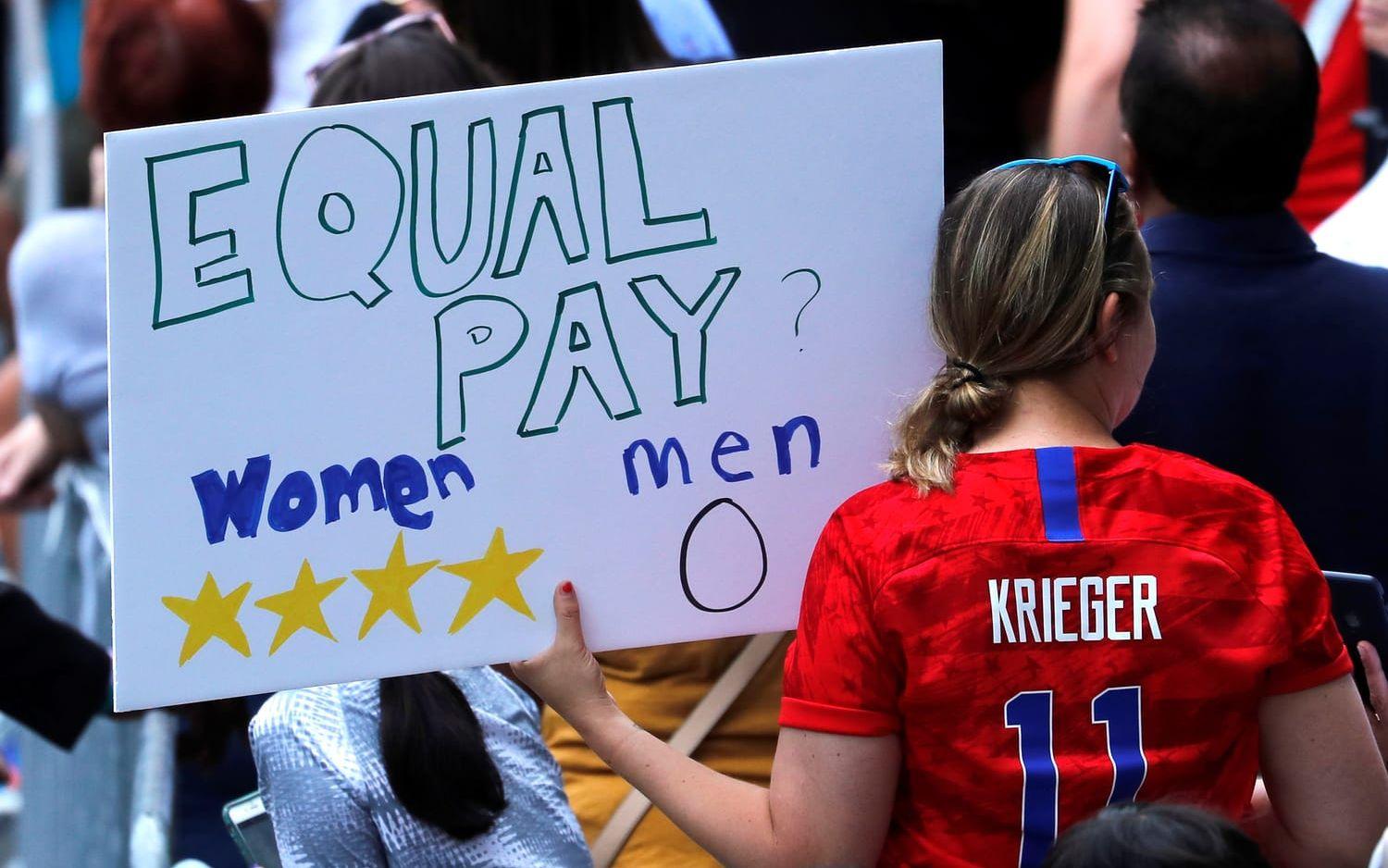 Den amerikanska publiken som tog sig till mästerskapet i Frankrike skanderade &quot;Equal pay&quot;, under paraden i New York fortsatte budskapet att dyka upp.