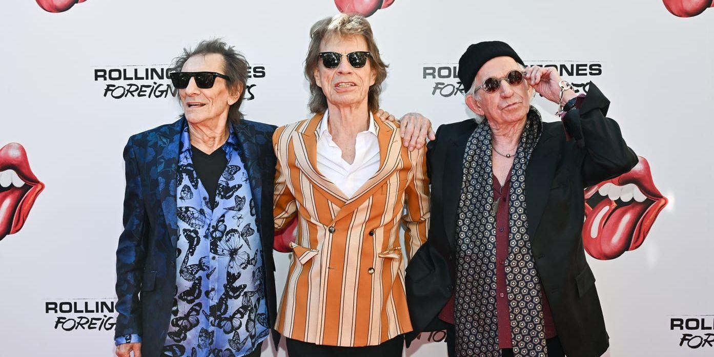 Ron Wood, Mick Jagger och Keith Richards poserar med armarna om varandra.