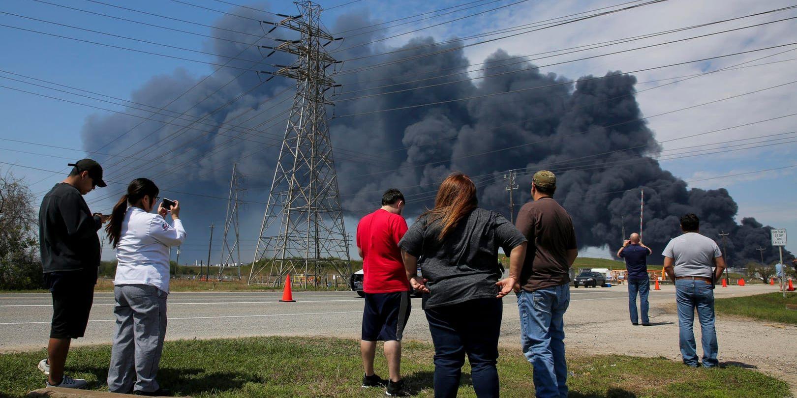 Personer i Houston, Texas samlas för att titta på rökmolnet som stiger från branden i ett företags lagringslokaler i staden.