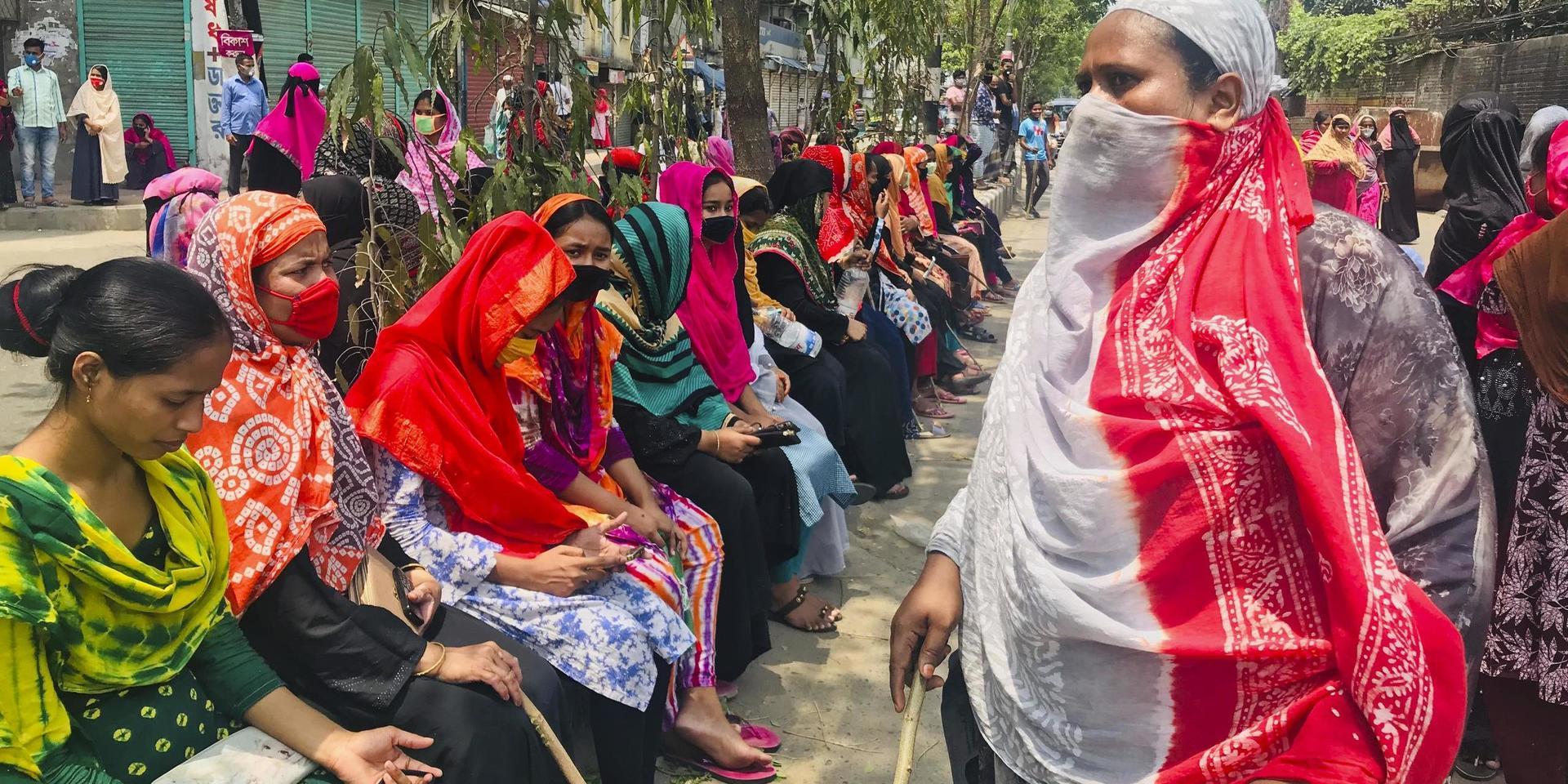 Bangladeshiska textilarbetare blockerar en väg under en protest förra året. De protesterade mot indragna löner under pandemin. Arkivbild.