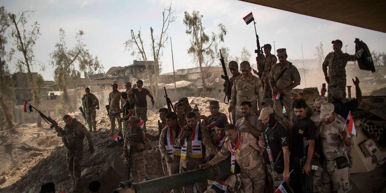 Irakiska armésoldater samlade för att fira sin framryckning mot Islamiska staten (IS) i Mosuls gamla stad.