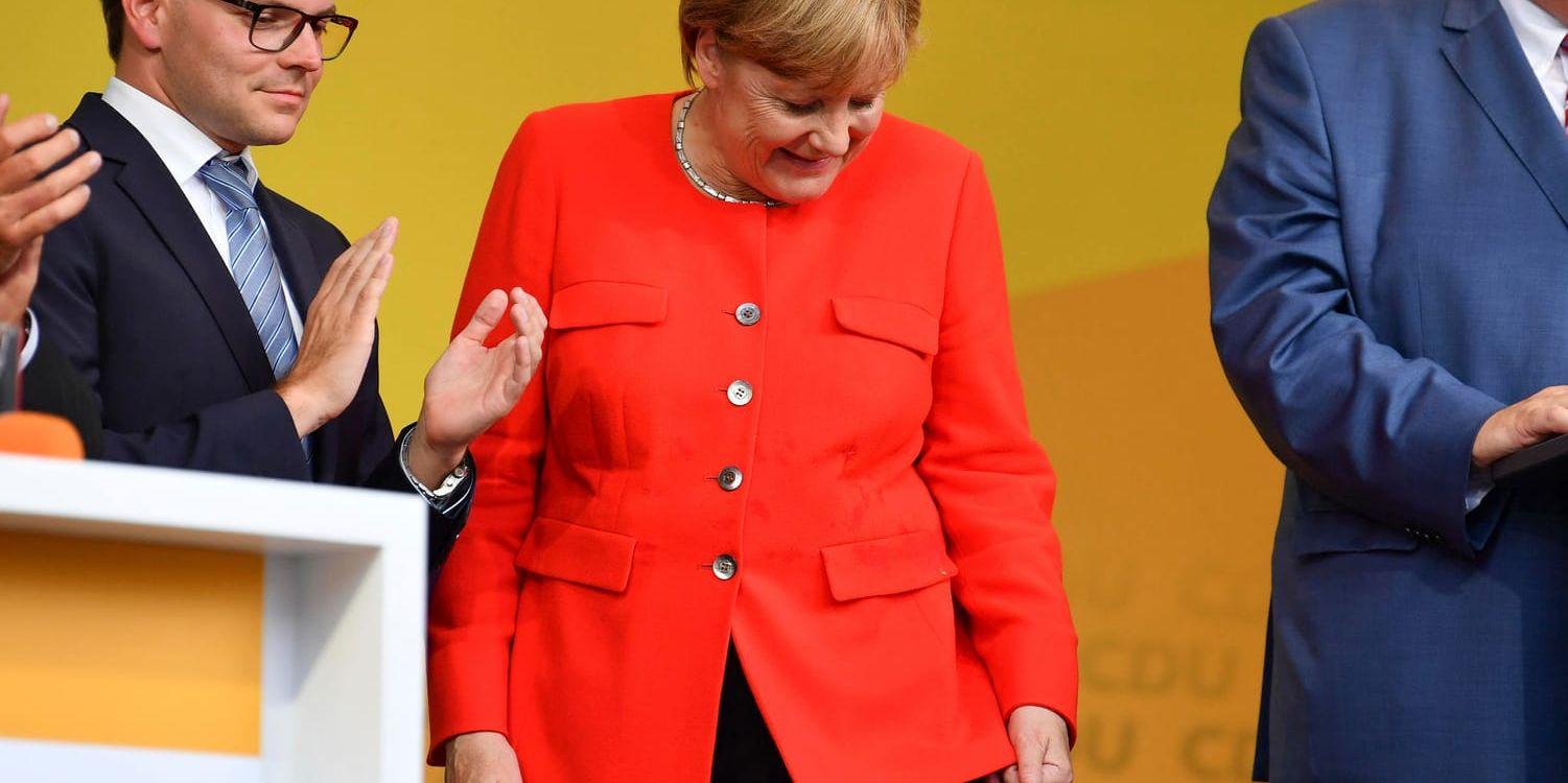 Angela Merkel tittar på en fläck på sin kavaj sedan hon fått en tomat kastad mot sig under ett valmöte i Heidelberg tidigare i veckan.
