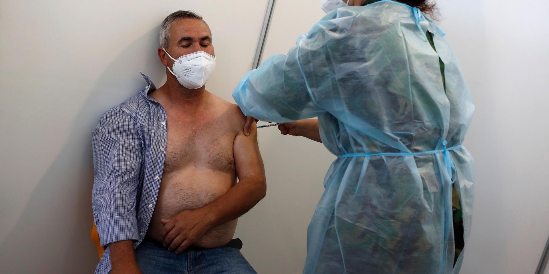 En man får vaccin mot covid-19 på ett vaccineringscenter vid universitetet i Lissabon. Portugal tillhör världstoppen när det gäller att vaccinera hela sin befolkning, fullt ut.