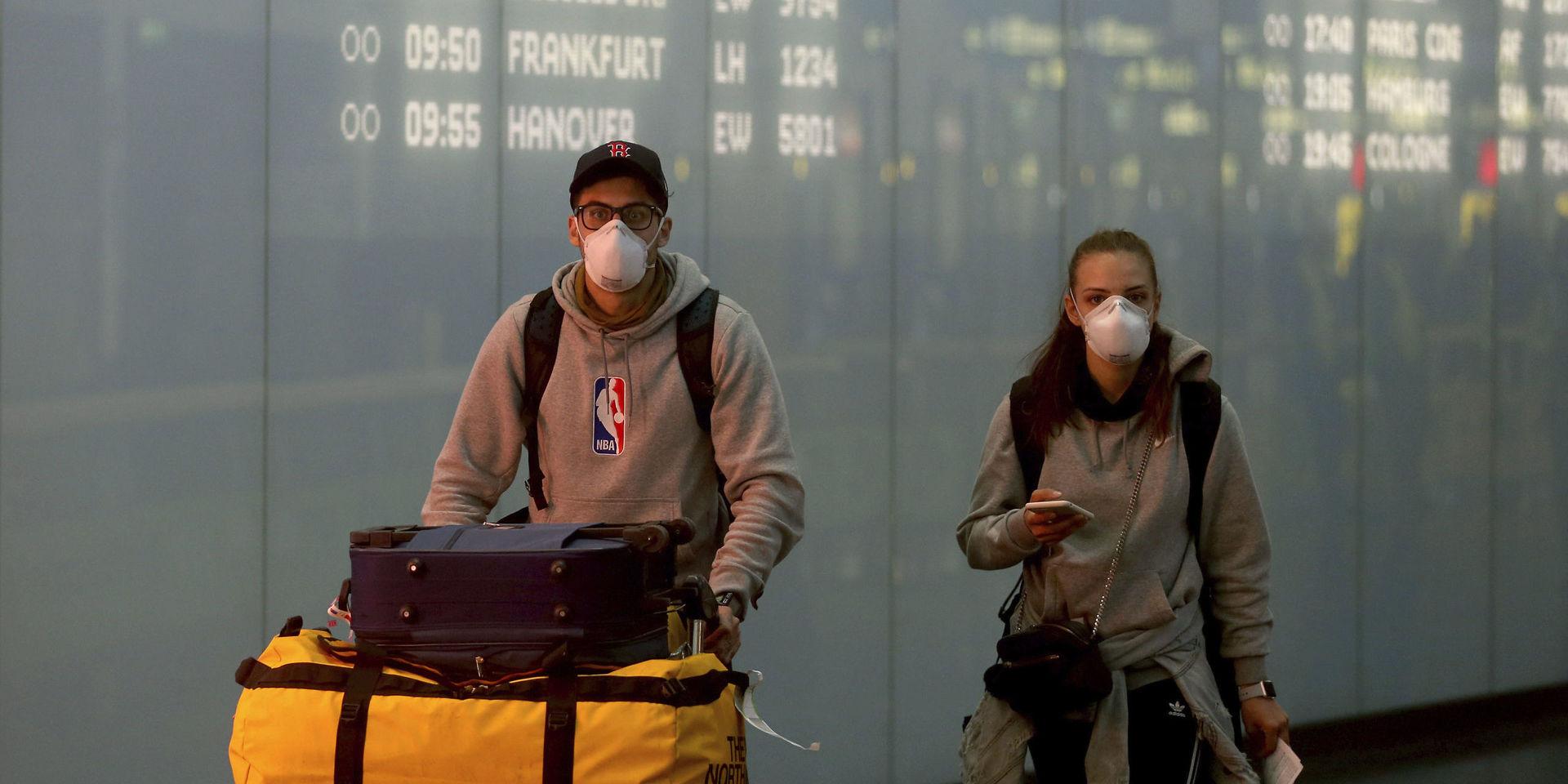Resenärer med munskydd på flygplatsen Schwechat i Wien. 